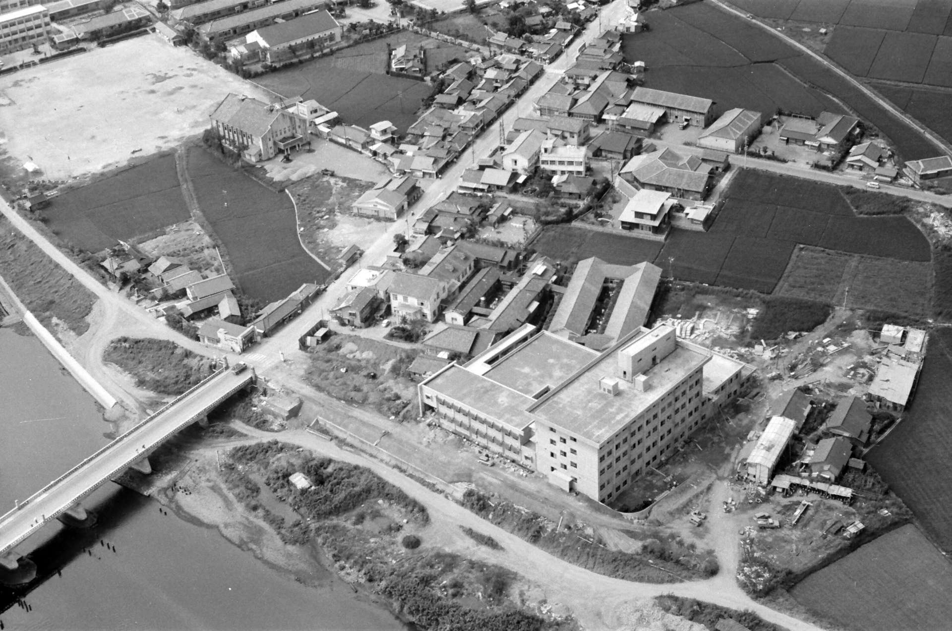 １９６６年完成後の出水市立病院（右下）の上空からの写真。近くには米之津川が流れる（出水総合医療センター提供）