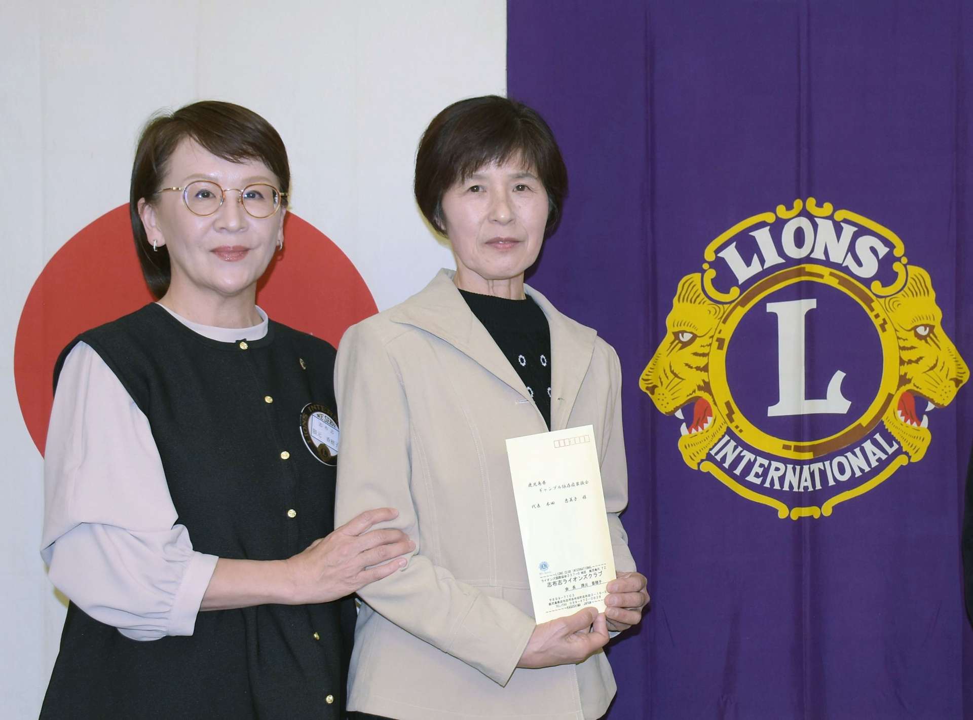 隈元香穂子会長（左）から寄付金を受け取る全国ギャンブル依存症家族の会鹿児島の本田恵美子さん＝３日、志布志市の大黒本店
