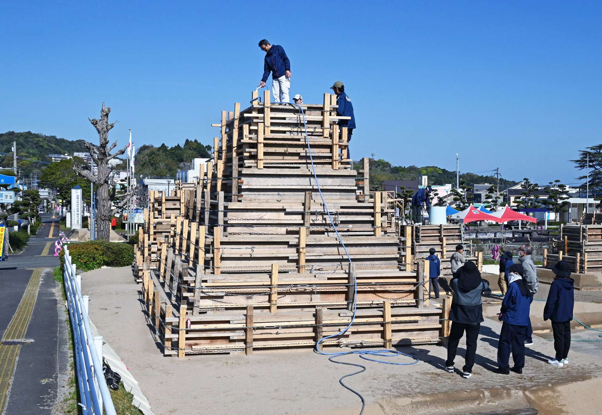 砂像作りに励む関係者＝７日、南さつま市役所前