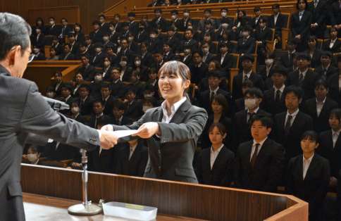 地頭所恵教育長から代表で辞令を受け取る新規採用教諭＝１日、鹿児島市のカクイックス交流センター