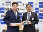 パッケージに標語が記されたパンを手にする黒瀬貴文部長（右）と岩城孝志交通部長＝７日、鹿児島市の県警本部