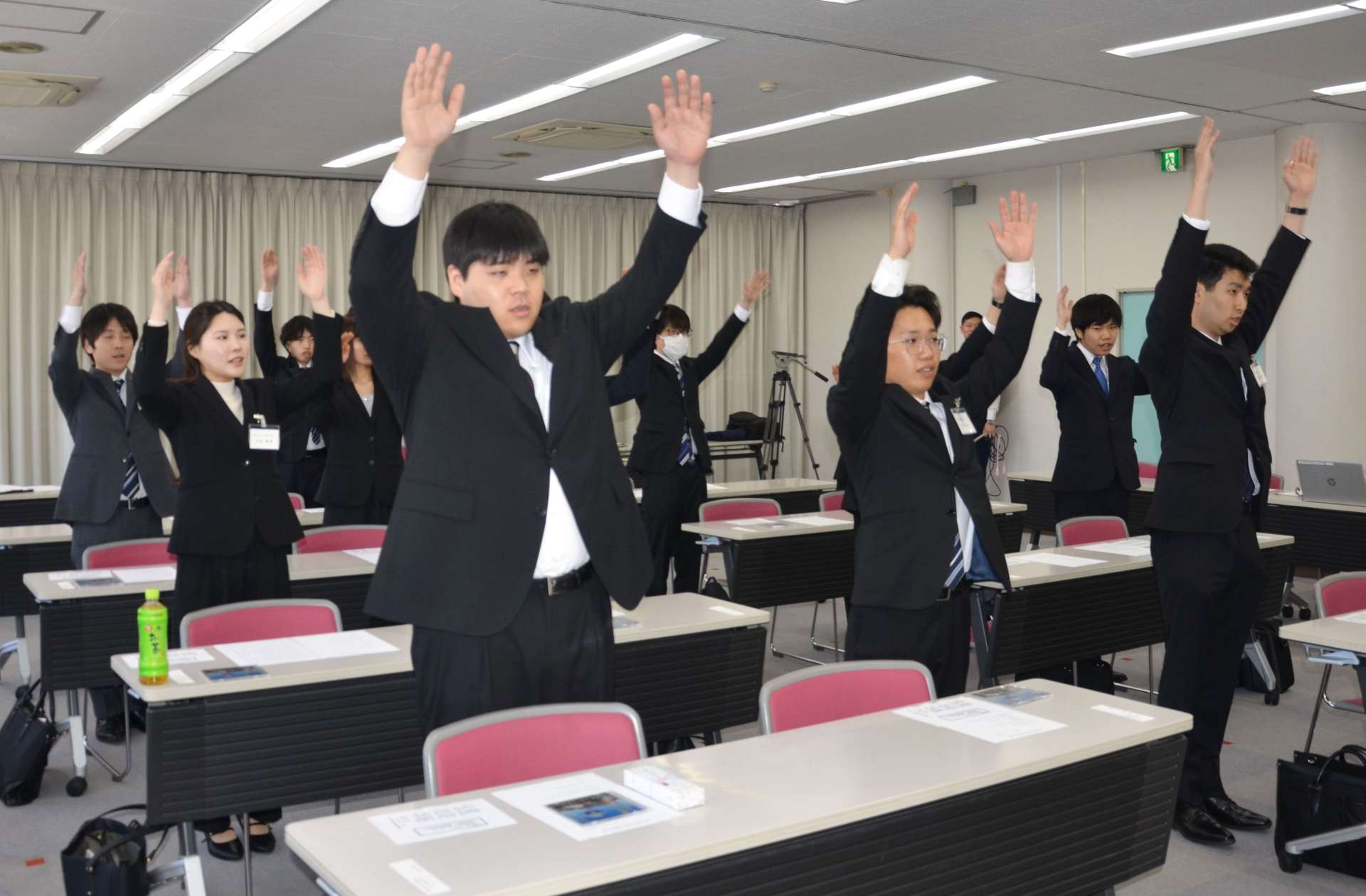万歳三唱する新入社員＝８日、鹿児島市卸本町のオロシティーホール