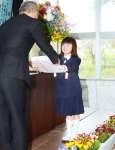 教科書を受け取る竹村心花さん＝８日、天城町の西阿木名小学校三京分校