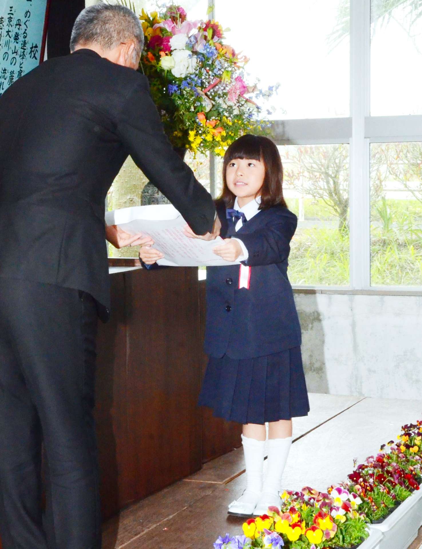 教科書を受け取る竹村心花さん＝８日、天城町の西阿木名小学校三京分校