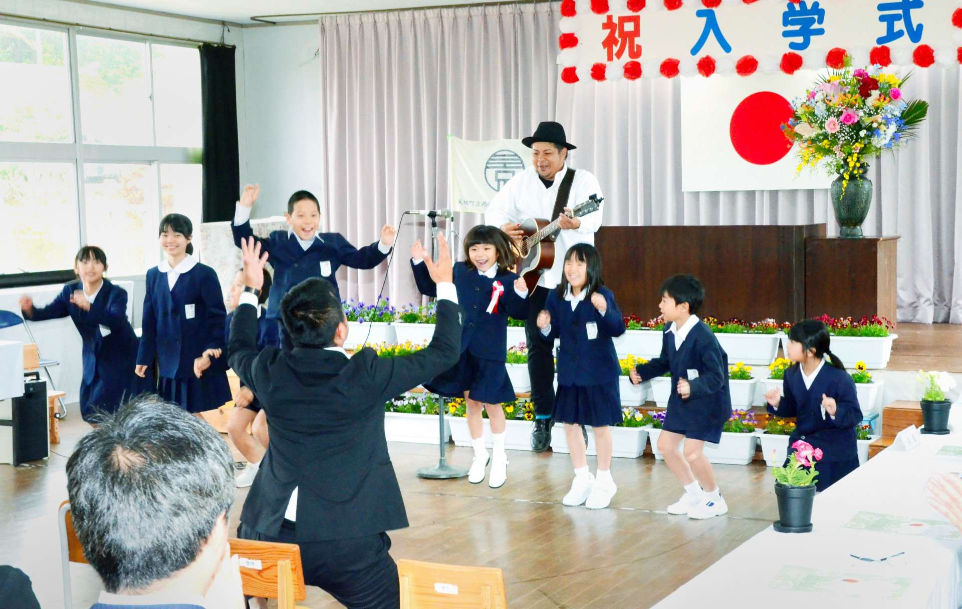 禎一馬さんの歌に合わせ踊る児童＝８日、天城町の西阿木名小学校三京分校