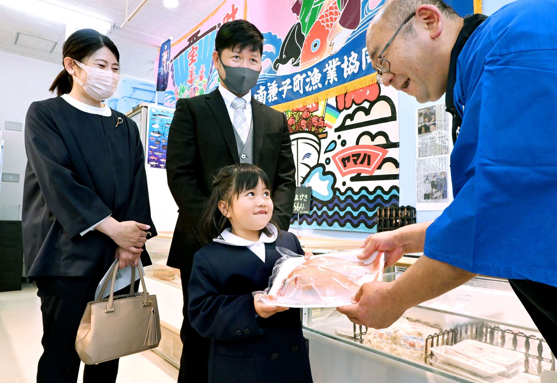 入学祝いのチコダイを受け取る河脇光凜さん（中央）ら＝７日、南種子町