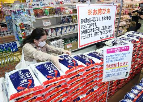 店頭に並んだ備蓄米を手に取る買い物客＝１０日、鹿児島市のＡコープ桜ケ丘店