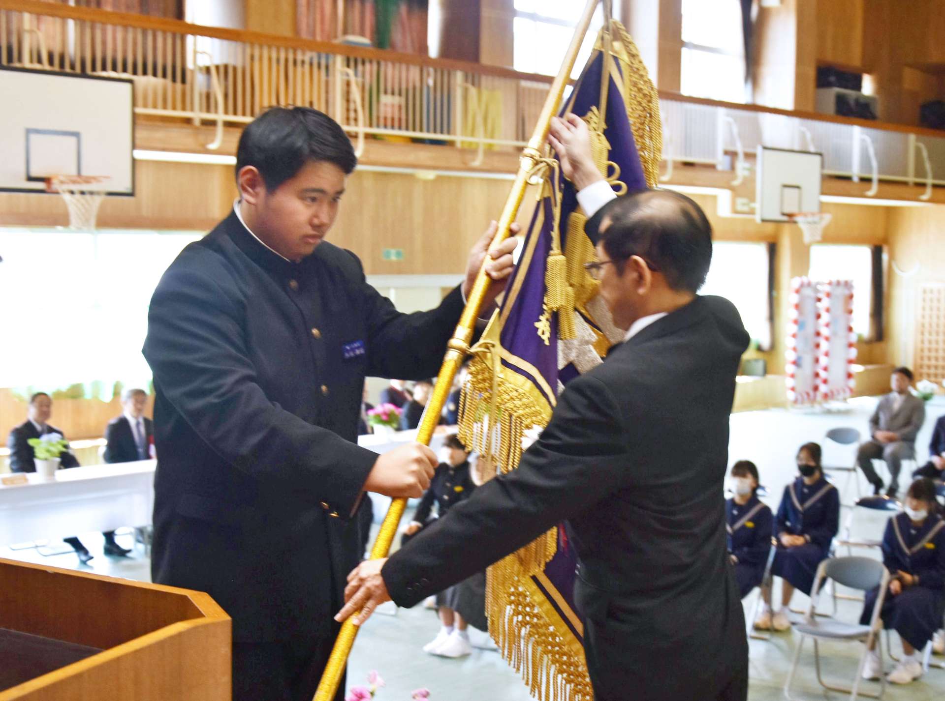 佐多地区小中一貫校開設式で校旗を渡す生徒代表＝南大隅町佐多
