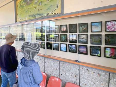 やまぐちめぐみさんの作品を眺める来場者＝霧島市牧園のＪＲ霧島温泉駅