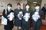 出水総合医療センターに寄贈した手作りの「キワニスドール」を持つ野田女子高校の生徒ら