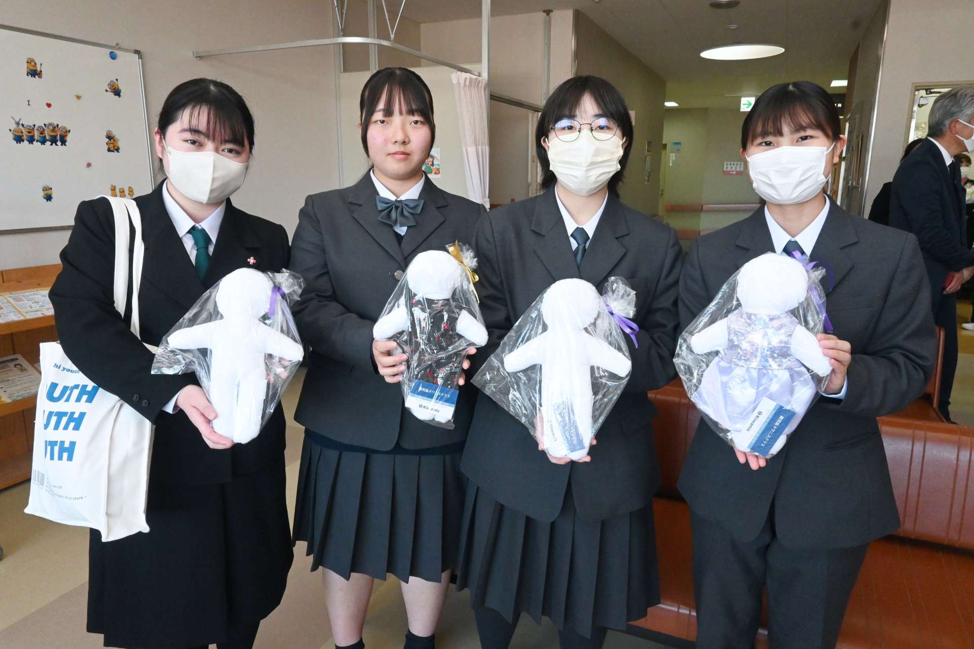 出水総合医療センターに寄贈した手作りの「キワニスドール」を持つ野田女子高校の生徒ら