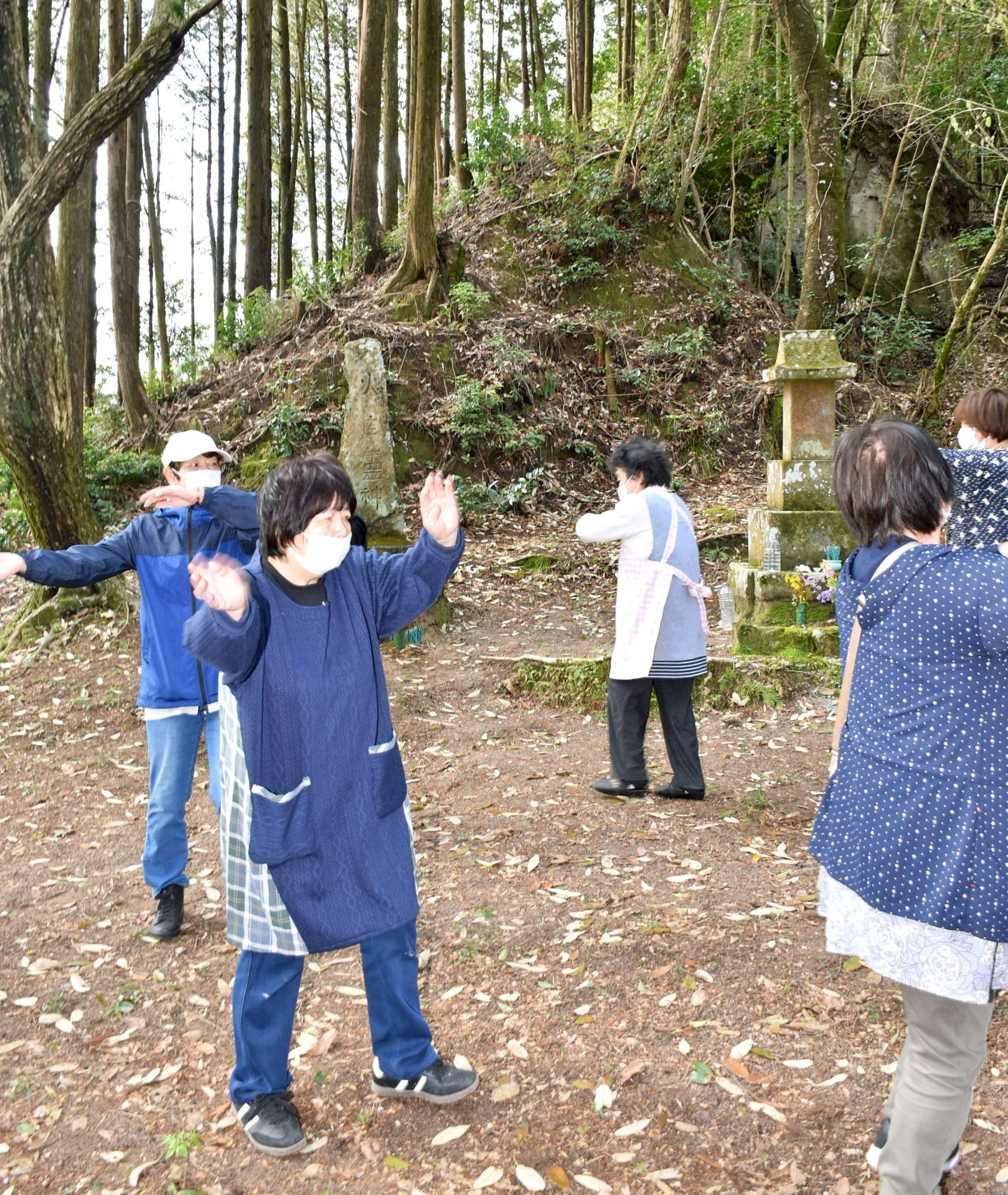 火と水の神さまの石碑に団子を供え、踊りを奉納する住民＝１３日、伊佐市菱刈川南