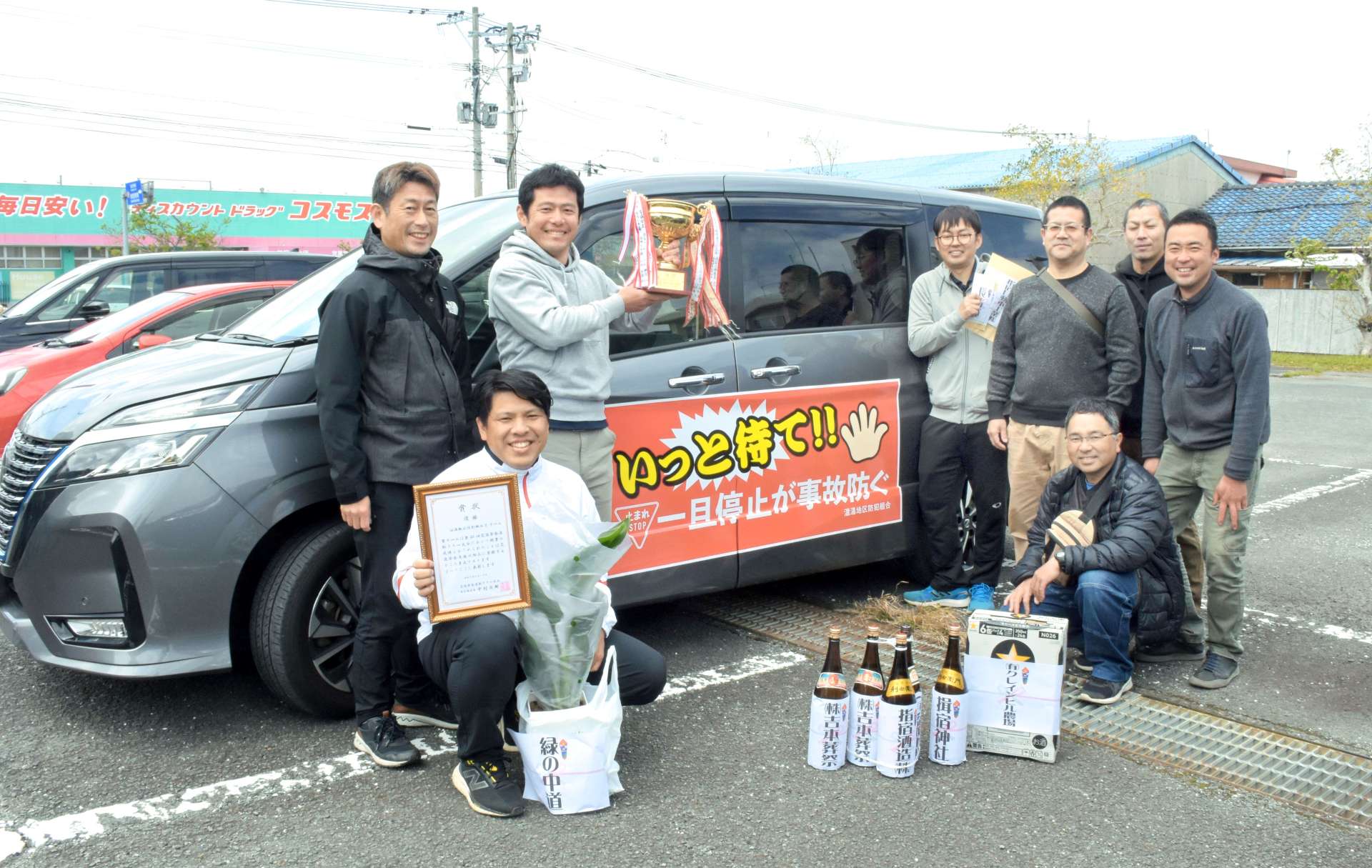 総合優勝に輝き、笑顔を見せる温湯地区防犯組合のメンバーら＝１３日、指宿市の指宿警察署