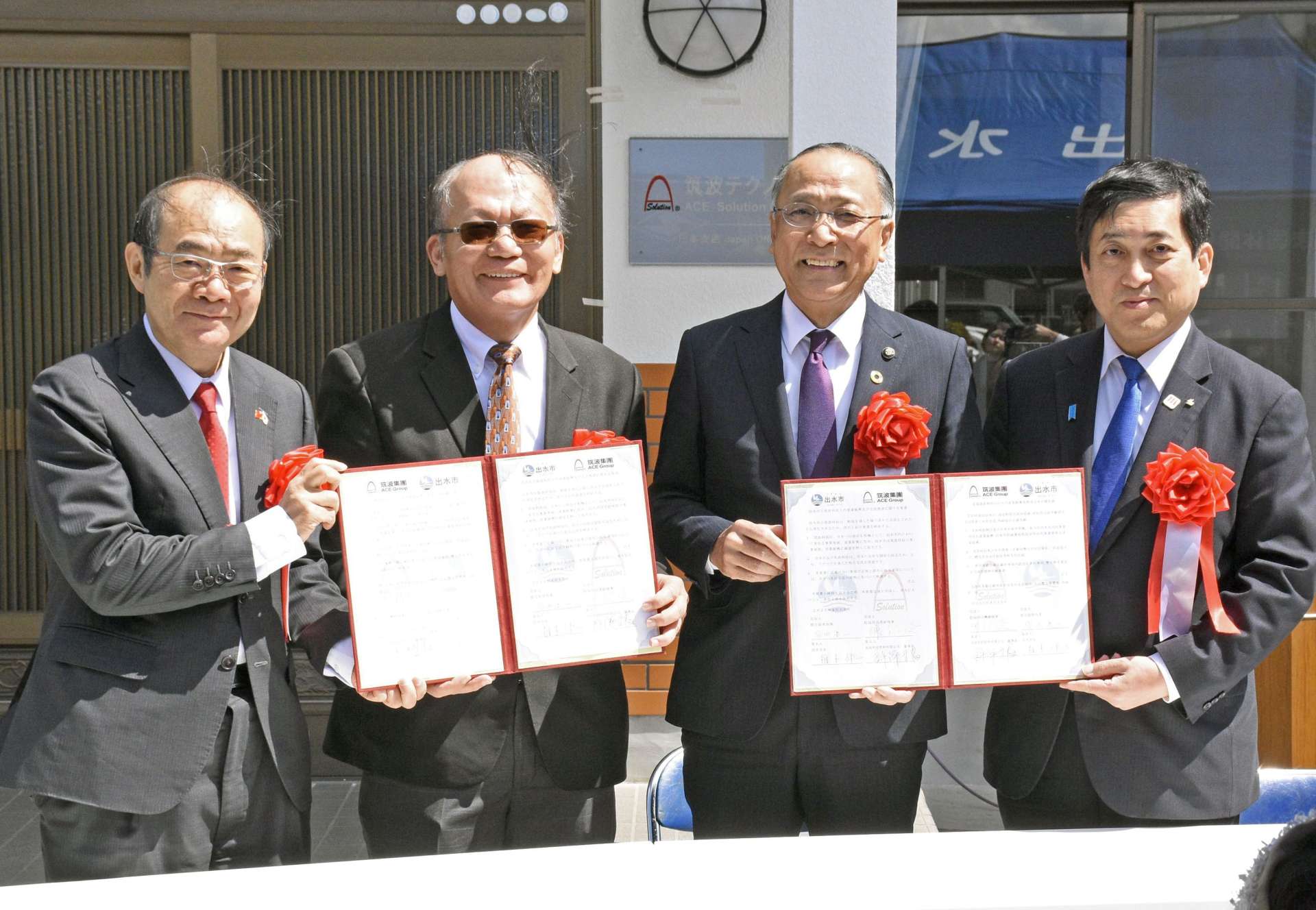 覚書を締結する許深福社長（左から２人目）と椎木伸一市長（同３人目）＝１５日、出水市上鯖渕