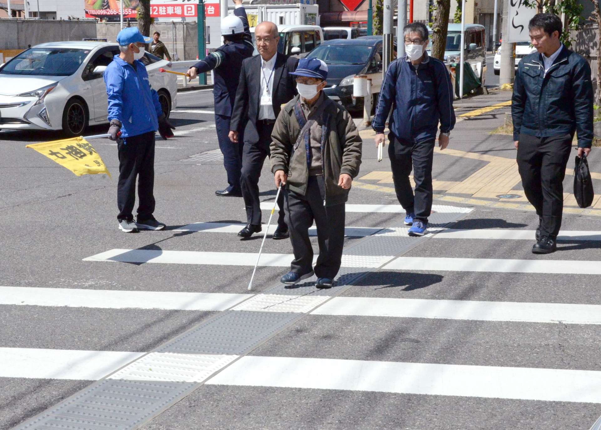 白線の間隔が広がった横断歩道を歩く参加者＝１５日、鹿児島市の谷山支所前交差点