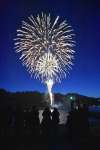 海上から打ち上げられ、春の夜空を彩る花火＝１５日、指宿市の山川漁港