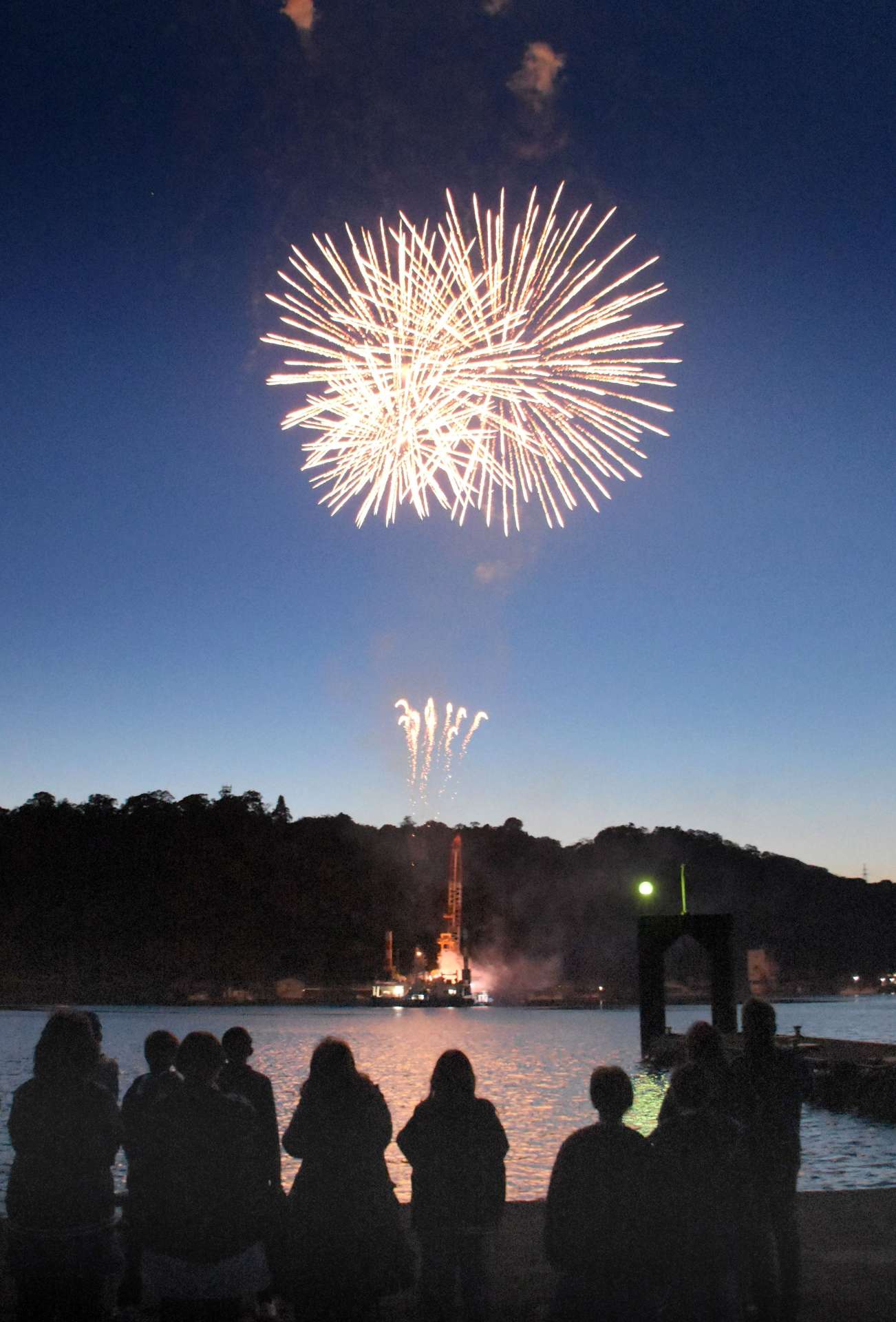 海上から打ち上げられ、春の夜空を彩る花火＝１５日、指宿市の山川漁港