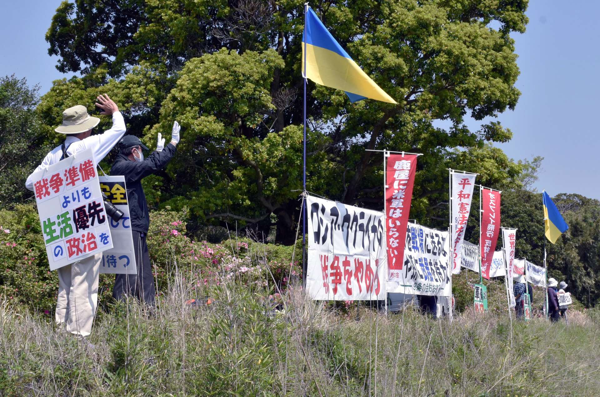鹿屋航空基地周辺で抗議活動する市民ら＝１６日、鹿屋市野里町