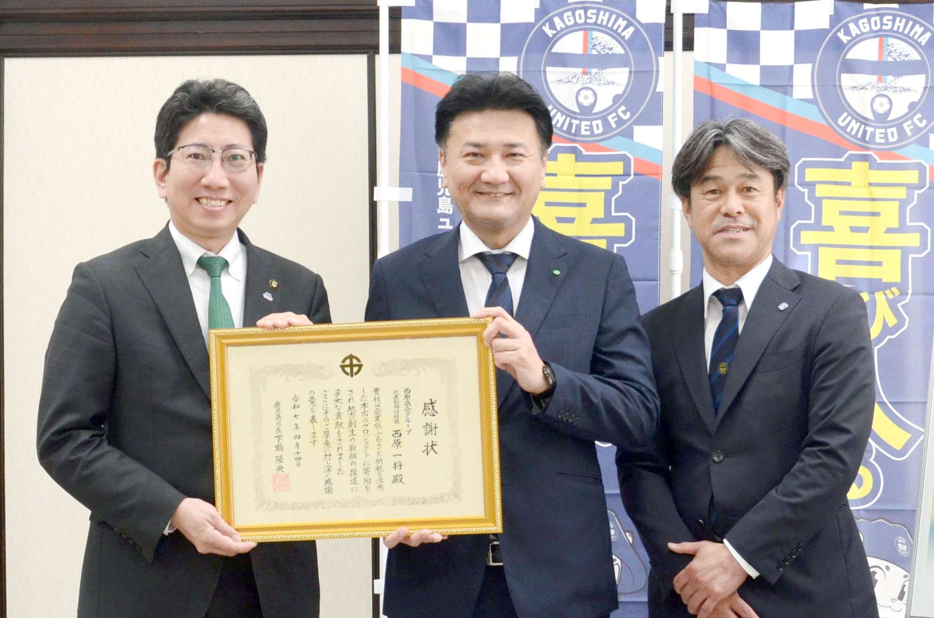 感謝状を手に記念撮影をする西原商会の山内涼太経理部長（中央）ら＝鹿児島市役所