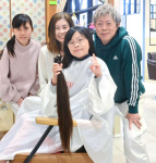 ヘアドネーションのために髪をカットし、家族と記念撮影をする後迫香凛さん（手前）＝鹿児島市与次郎１丁目