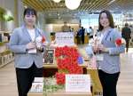 開館３周年をバラの飾りでアピールするスタッフ＝鹿児島市の天文館図書館