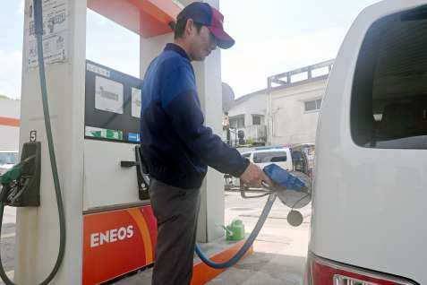 給油するガソリンスタンド店員。この日のレギュラーガソリンは１リットル当たり２１０円だった＝１７日、西之表市西之表