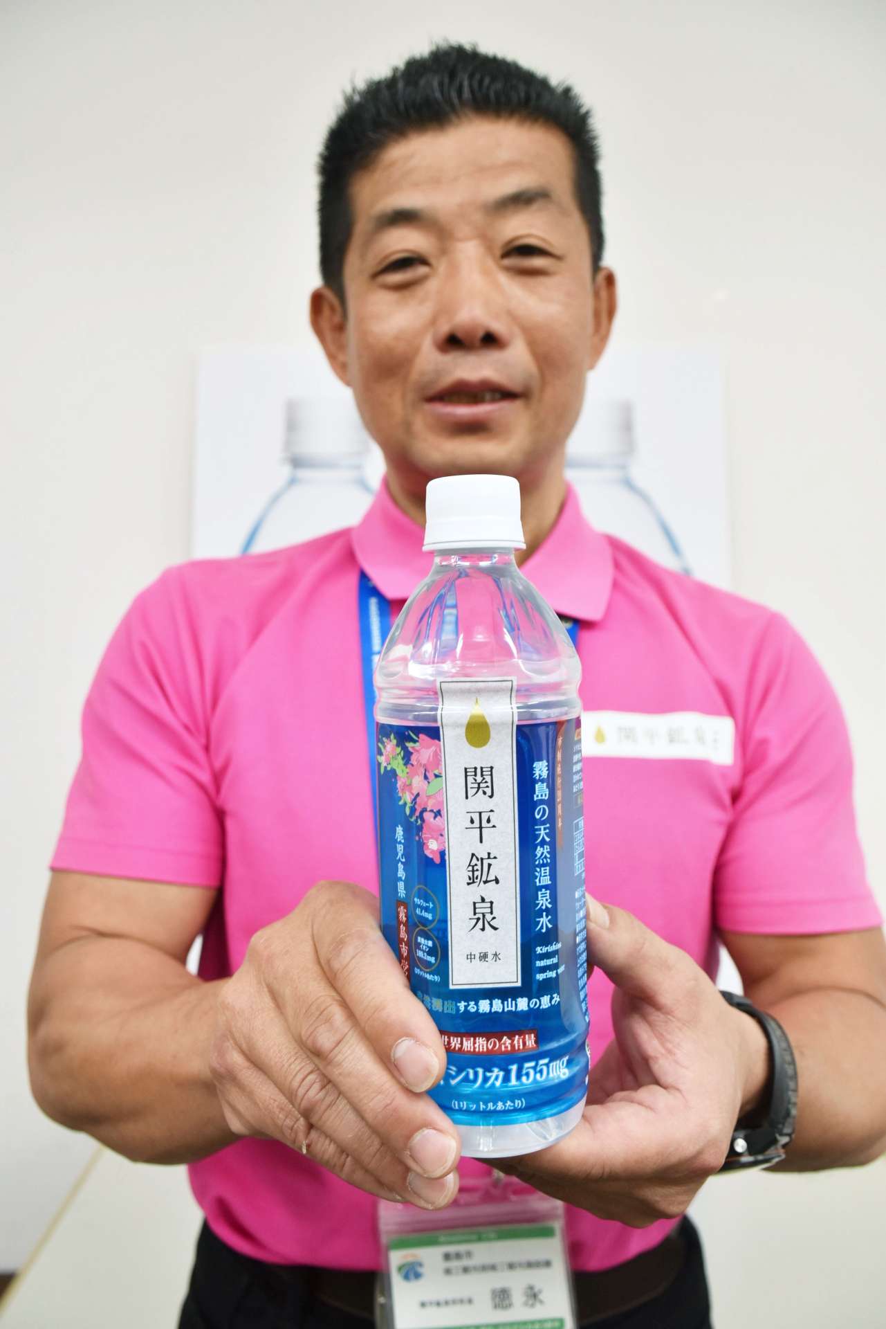市制施行２０周年記念ボトルを手にする市職員＝霧島市役所