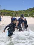 海に飛び込み、はしゃぐ児童＝２４日、西之表市の浦田海水浴場
