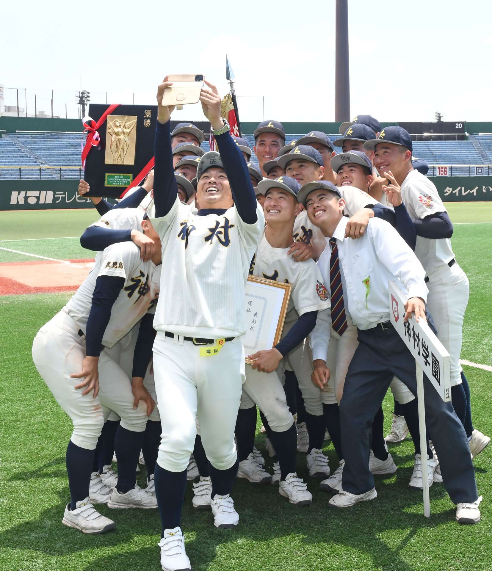 優勝の記念に写真を撮る神村の小田監督と選手＝長崎県営野球場