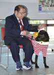 盲導犬のフィルと給付式に臨む川崎清之さん＝２４日、鹿児島県庁