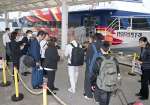 種子屋久高速船チャーター便への乗船手続きをする馬毛島工事関係者ら＝２５日、西之表市の西之表港