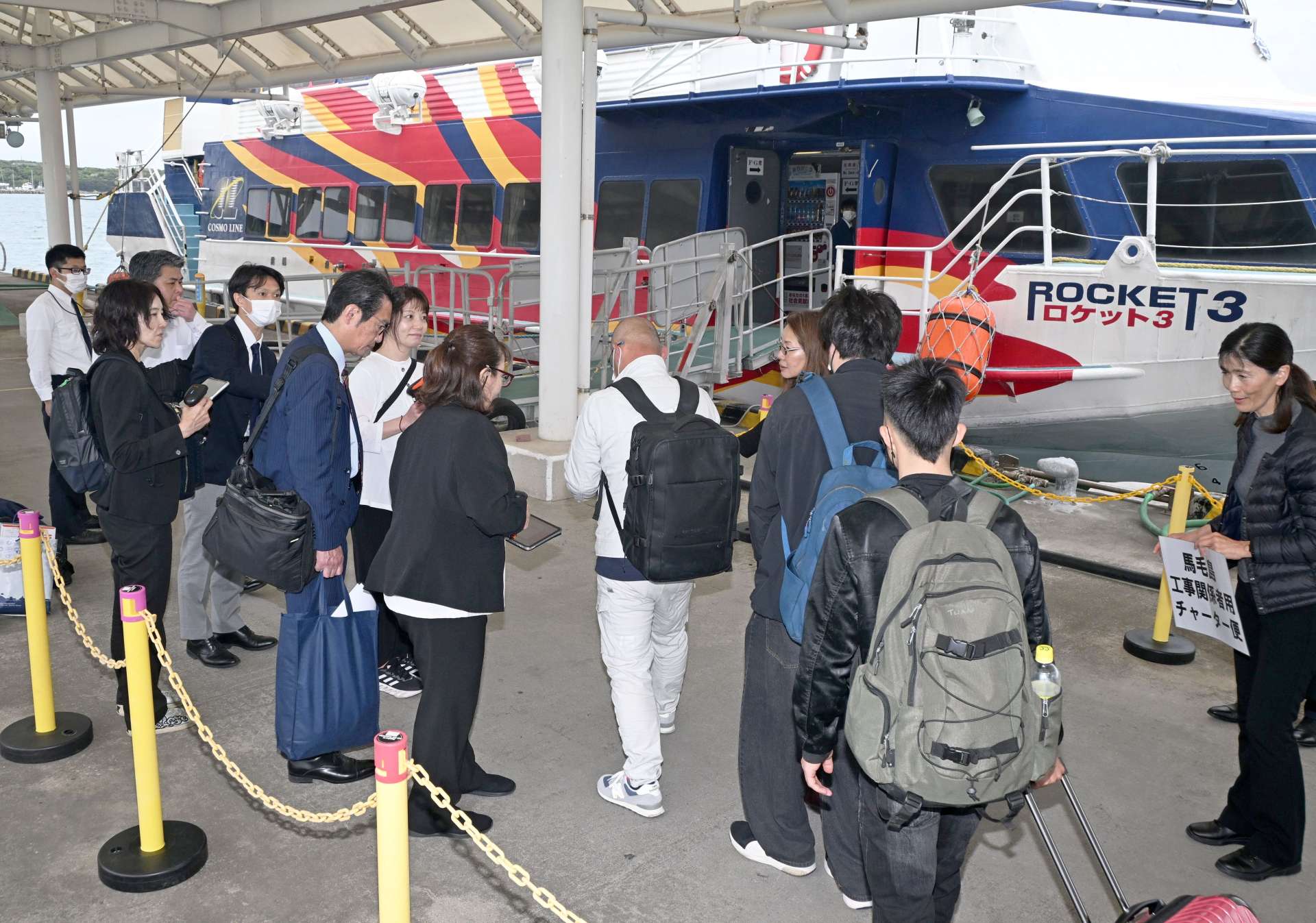 種子屋久高速船チャーター便への乗船手続きをする馬毛島工事関係者ら＝２５日、西之表市の西之表港