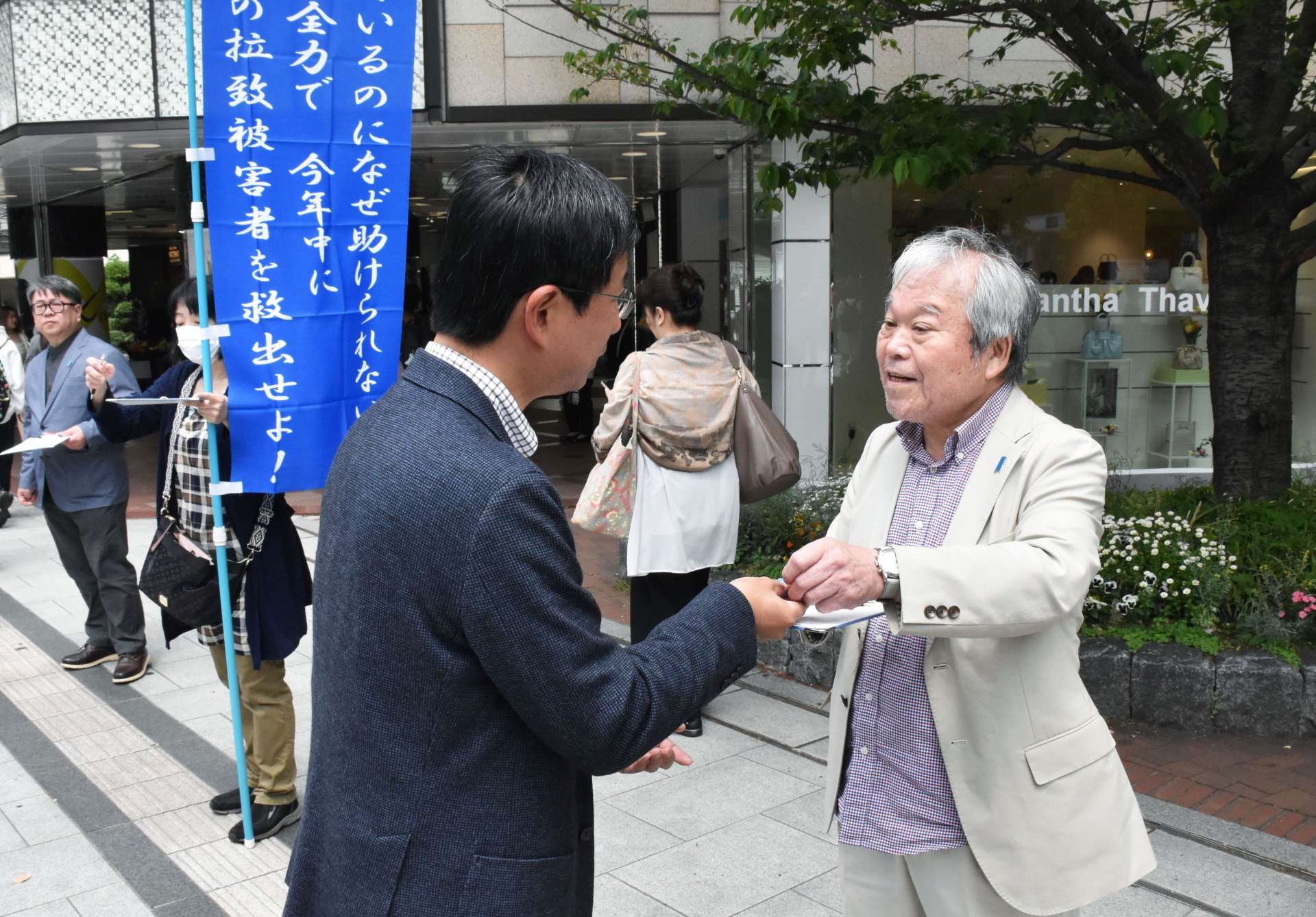 署名に協力を求める増元照明さん（右）＝２６日、東京・銀座