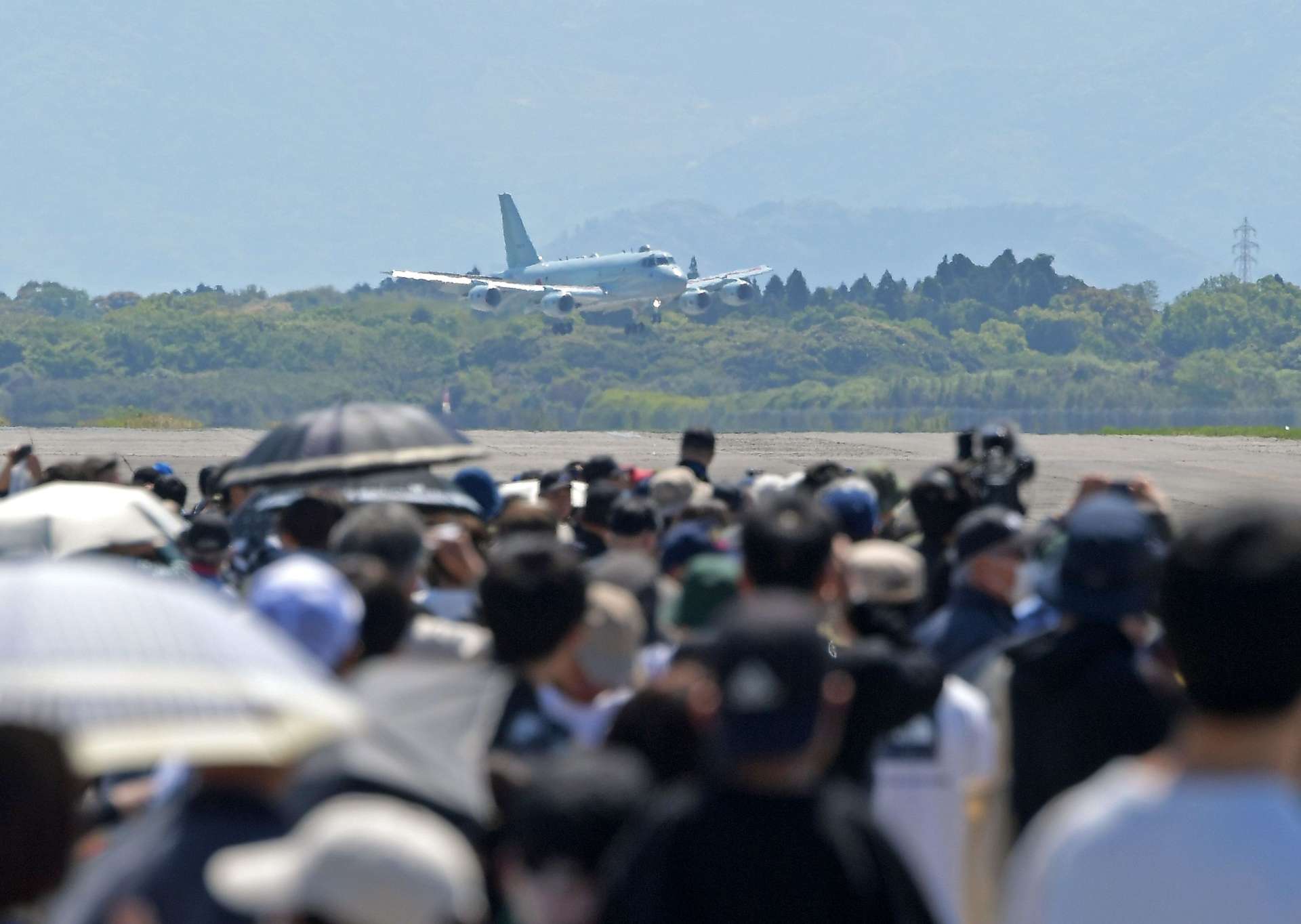 大勢の来場者が見つめる中、着陸する海上自衛隊のＰ１哨戒機＝鹿屋市の海上自衛隊鹿屋航空基地