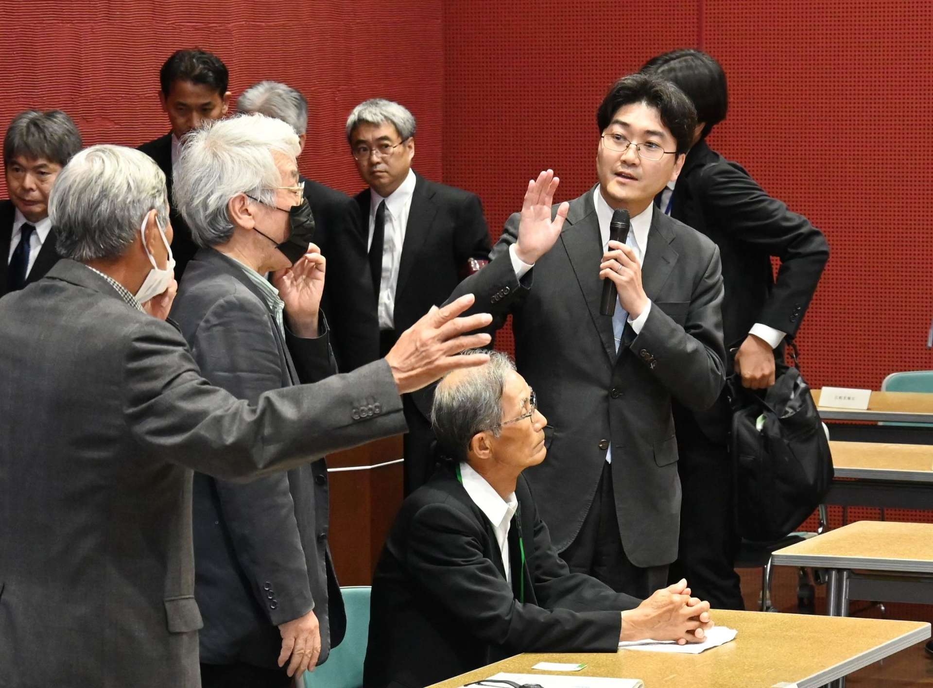 〈資料写真〉２０２４年５月１日、懇談会でマイクを切った国の対応に抗議する被害者団体関係者ら（左）＝熊本県水俣市の水俣病情報センター