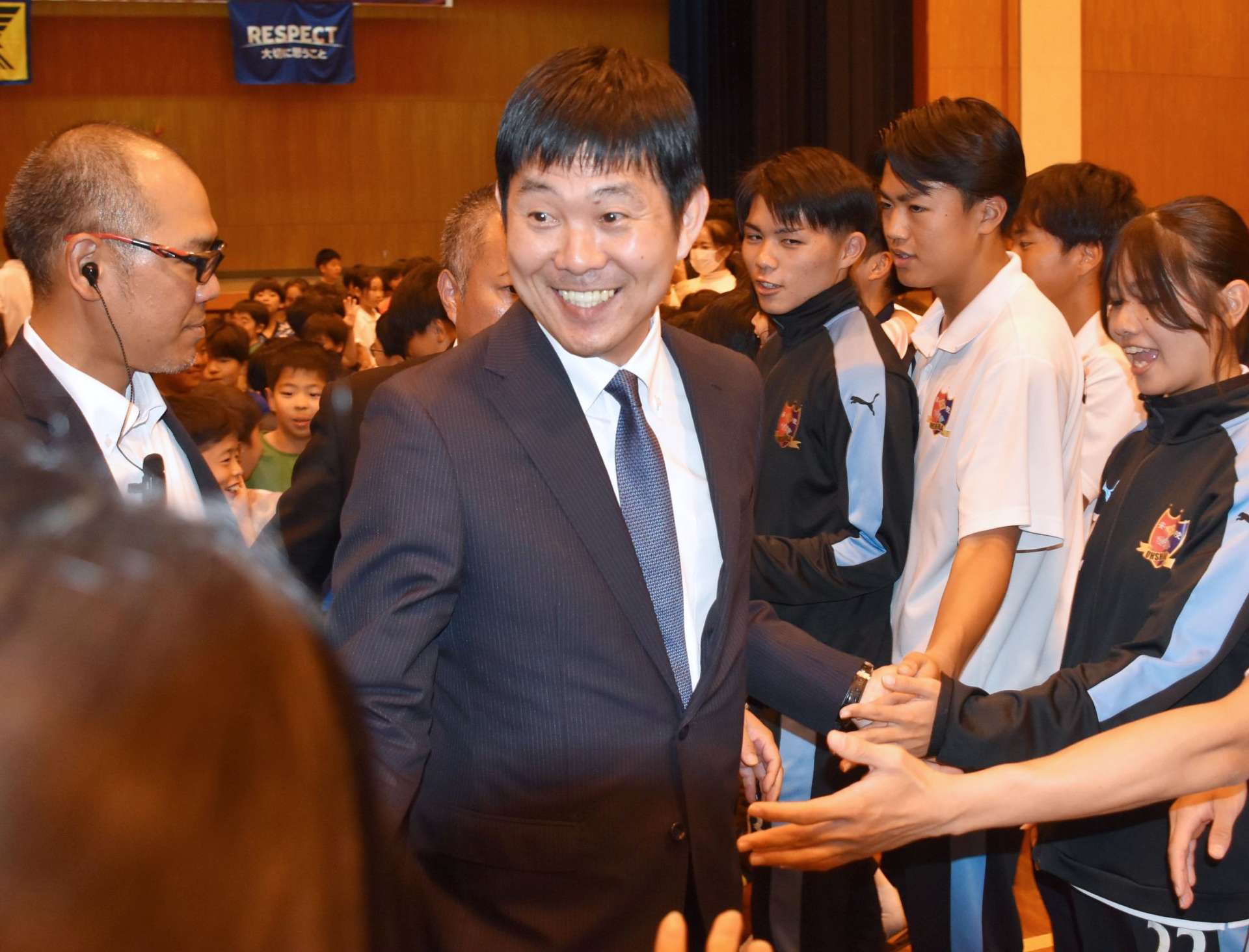 講演を終え、来場者と握手しながら退場する森保一監督＝２７日、奄美市笠利