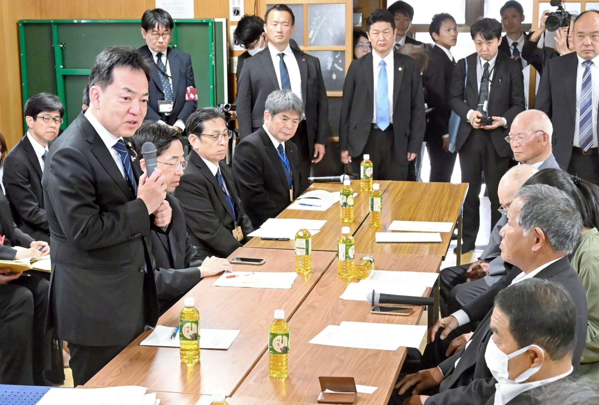 懇談前にあいさつする浅尾慶一郎環境相（左）＝１日、熊本県水俣市の出月公民館