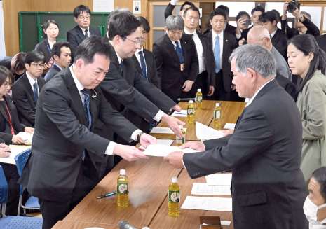 浅尾慶一郎環境相（左）に要望書を渡す水俣病被害者獅子島の会の滝下秀喜会長＝１日、熊本県水俣市の出月公民館