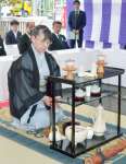 樋渡次右衛門の記念碑に献上する茶を入れる煎茶道知足庵流の家元＝１日、鹿児島市の県茶市場