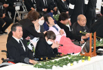 献花して手を合わせる慰霊式の参列者＝１日、熊本県水俣市のエコパーク水俣親水緑地