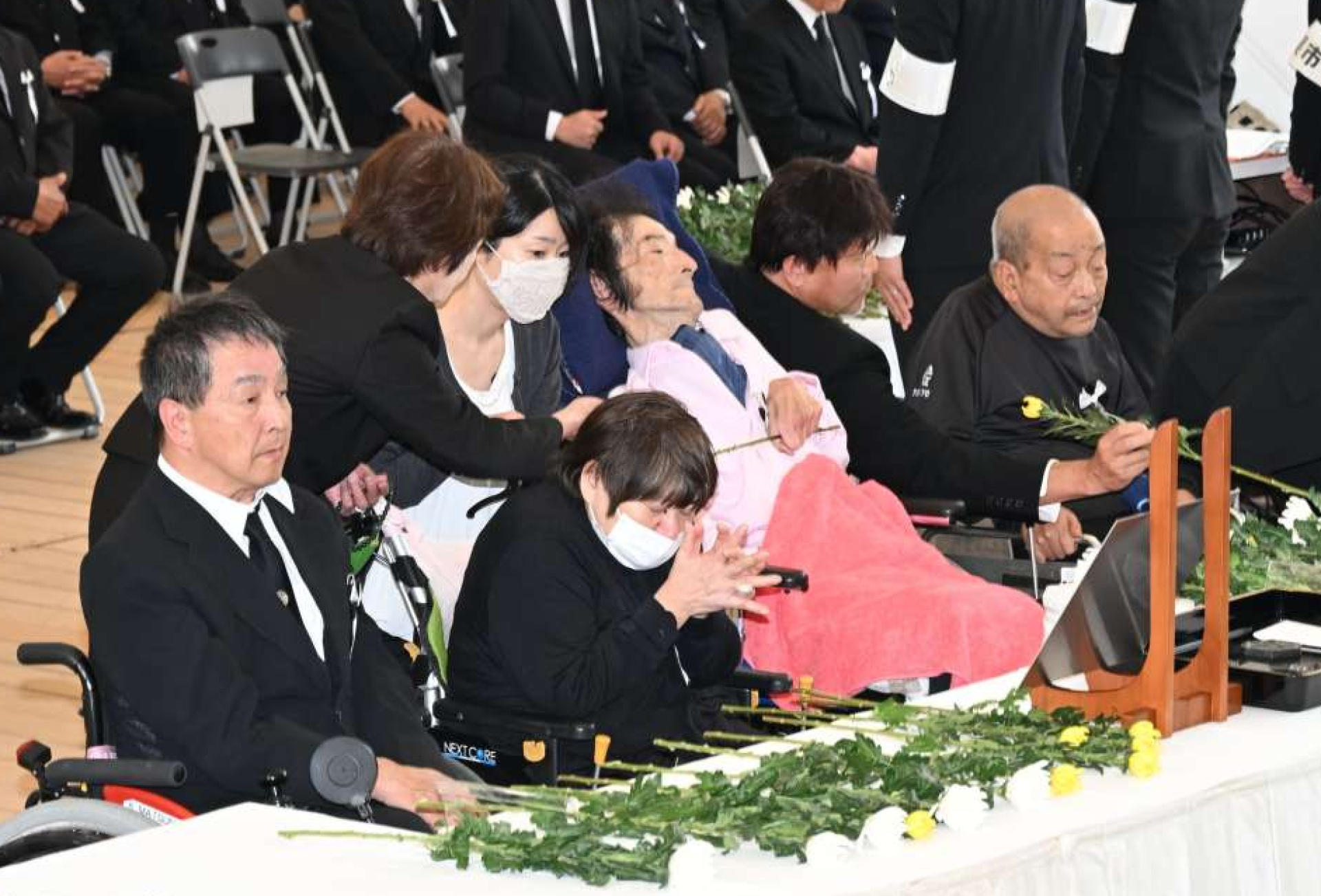 献花して手を合わせる慰霊式の参列者＝１日、熊本県水俣市のエコパーク水俣親水緑地
