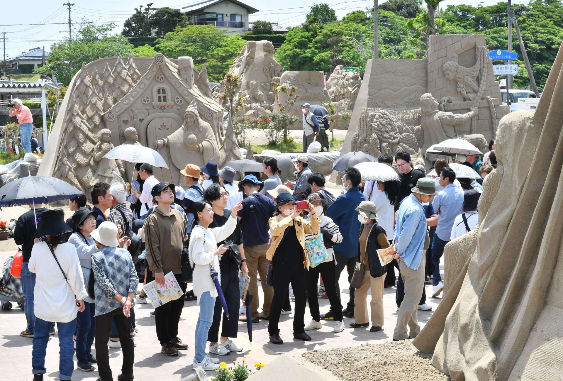 砂像を撮影する来場者でにぎわう会場＝３日、南さつま市役所