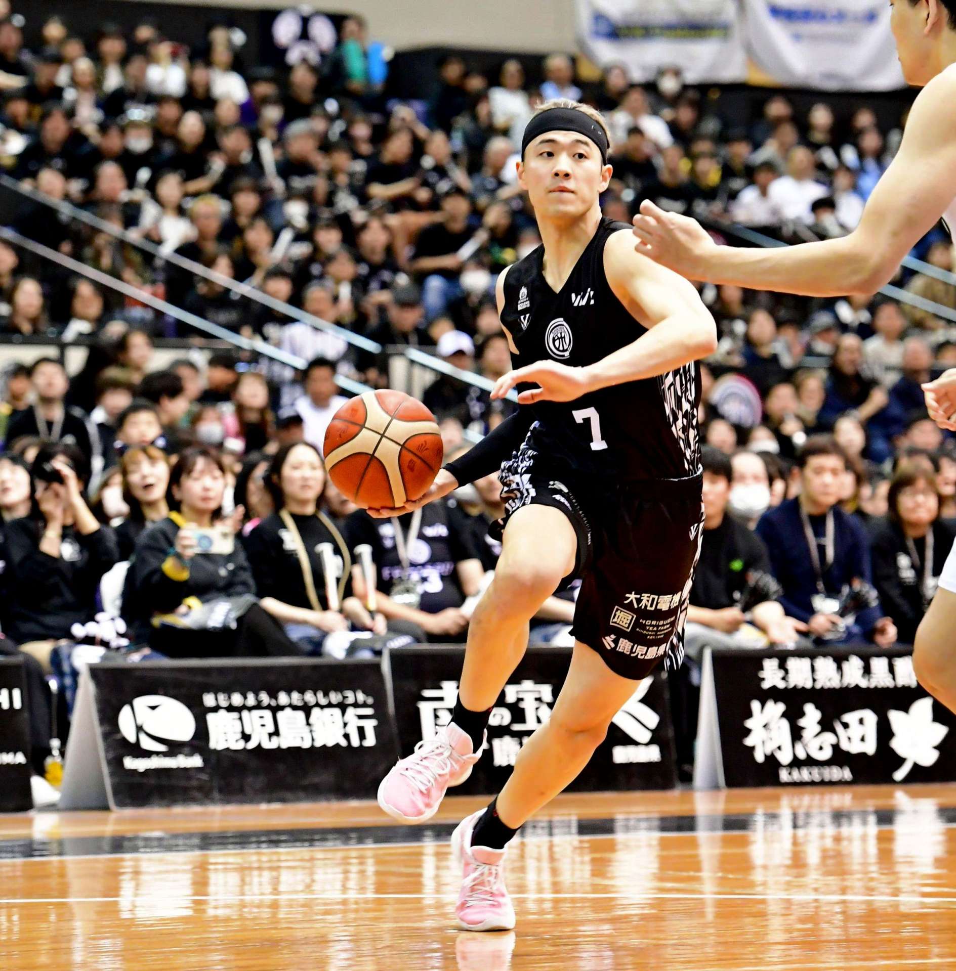 第１クオーター、ドリブルで切り込む鹿児島レブナイズの飴谷（７）＝鹿児島市の西原商会アリーナ