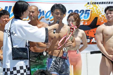 優勝トロフィーを手に喜びを語る倉富柾樹さん（中央）＝鹿屋市の海上自衛隊鹿屋航空基地
