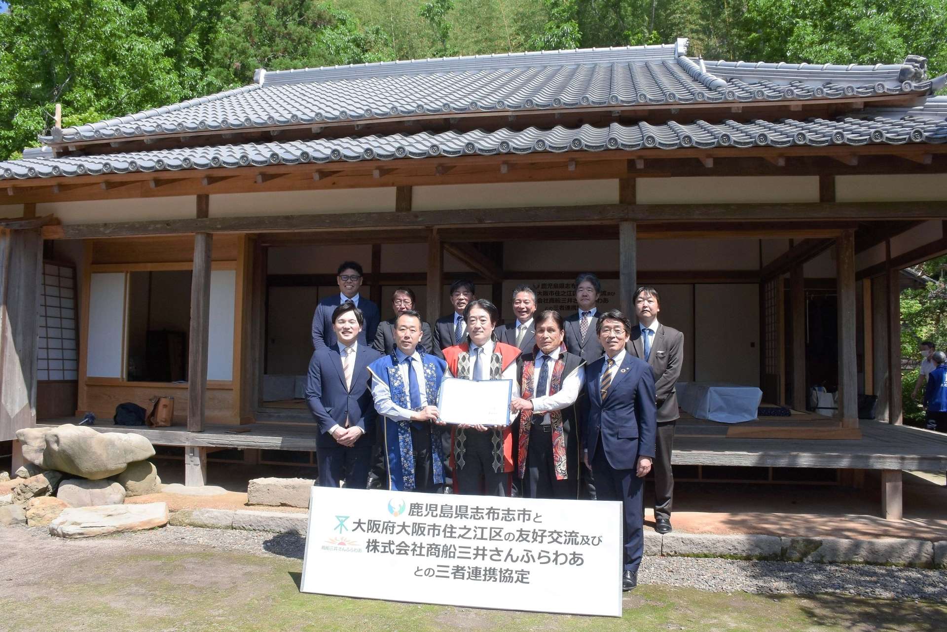 連携協定書を手にする志布志市、大阪市住之江区、商船三井さんふらわあの関係者＝志布志市の福山氏庭園