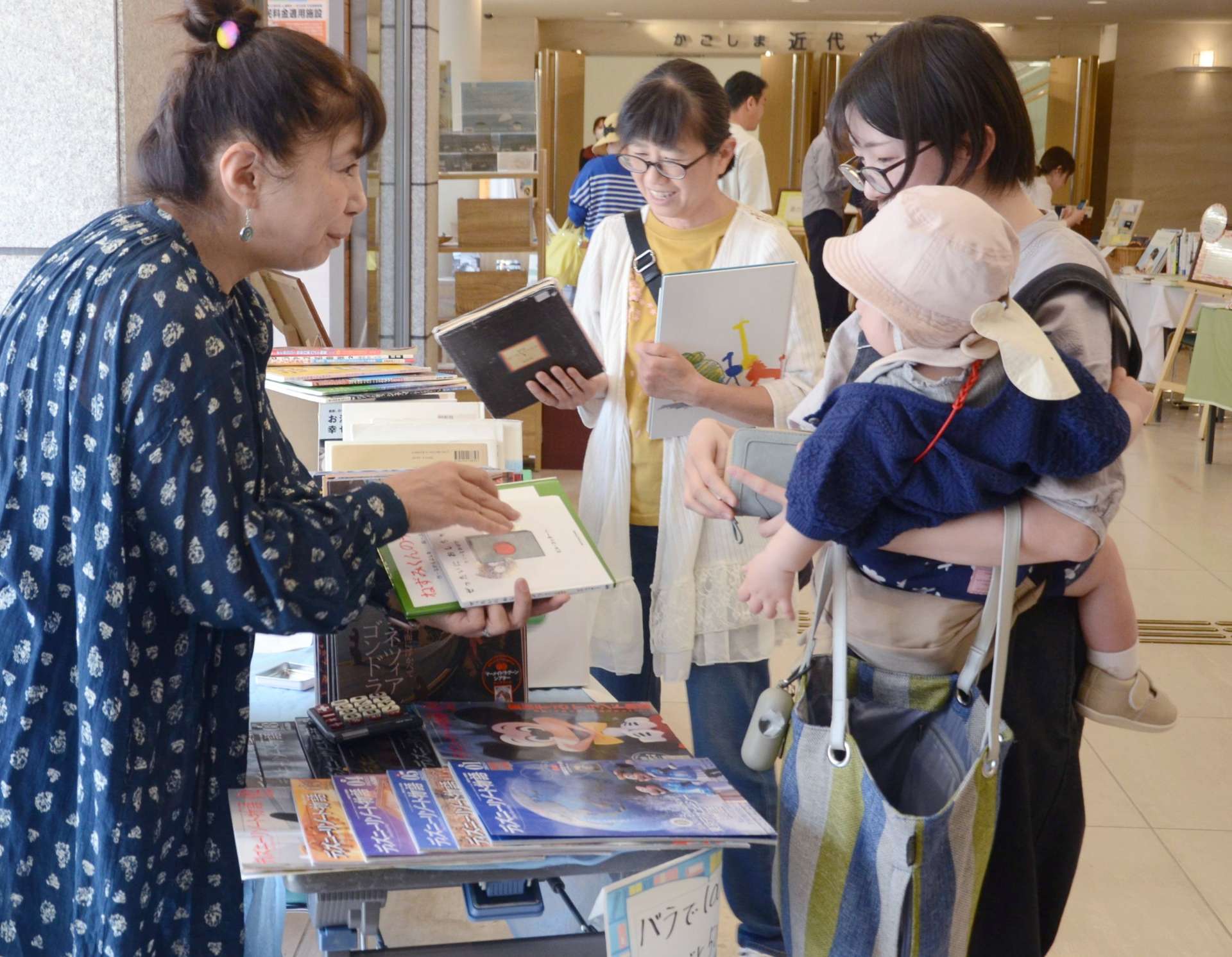 ブックマルシェで絵本を購入する入館者＝鹿児島市のかごしま近代文学館・かごしまメルヘン館