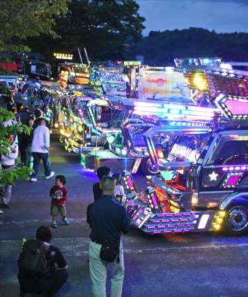 きらびやかに輝くトラックに見入る家族連れら＝伊佐市菱刈農村公園