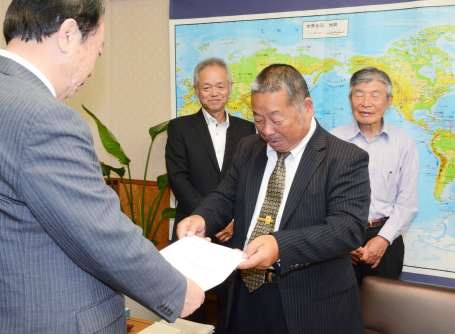 日高滋議長（左）に決起大会の報告書を手渡す磯辺昭信会長＝８日、県議会