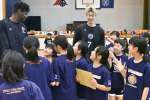 子どもたちと交流するレブナイズの伴馬（左）と飴谷＝４月、鹿児島市の清水小学校