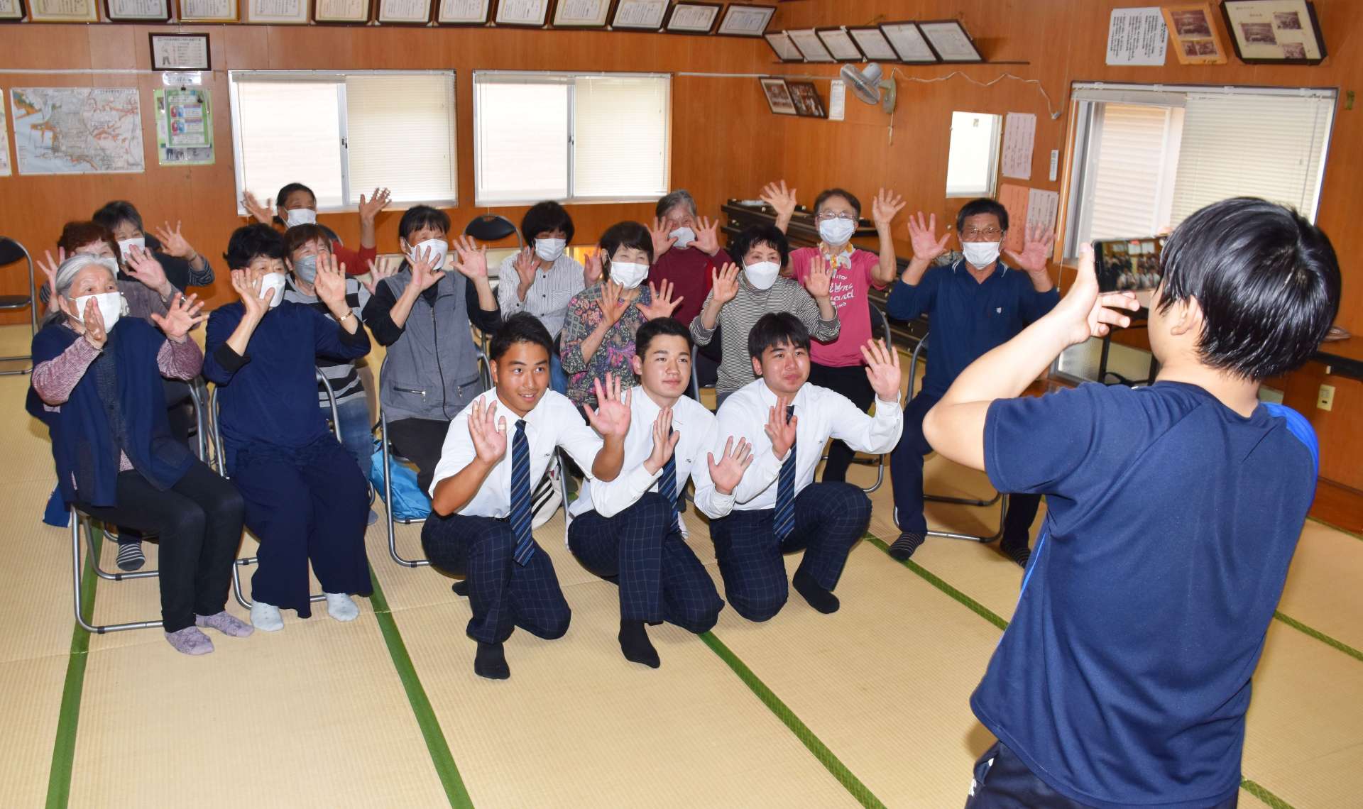 ころばん体操参加者の協力を得て、ＰＲ動画を作成する串木野高校生＝いちき串木野市の御倉町公民館